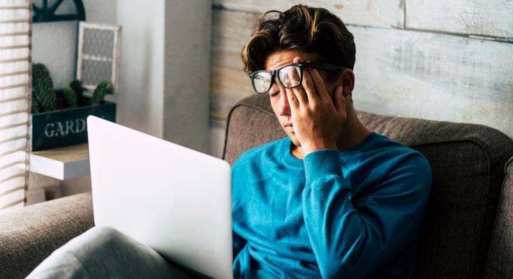 A young man with glasses, showing signs of frustration as he grapples with a challenging homework assignment, embodying the struggle of the learning process.