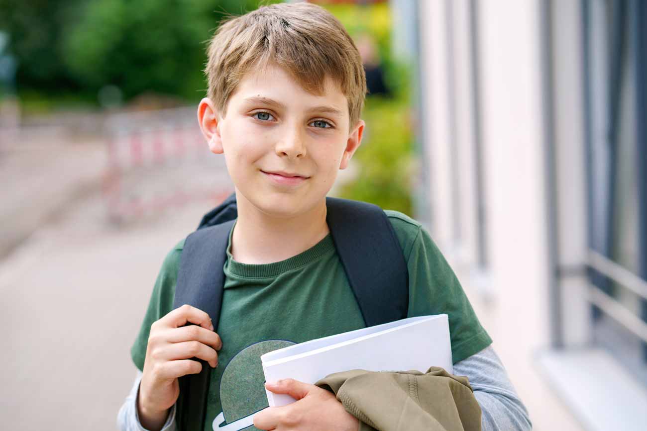 Student wearing a backpack that contains an executive function planner, prepared for academic success.